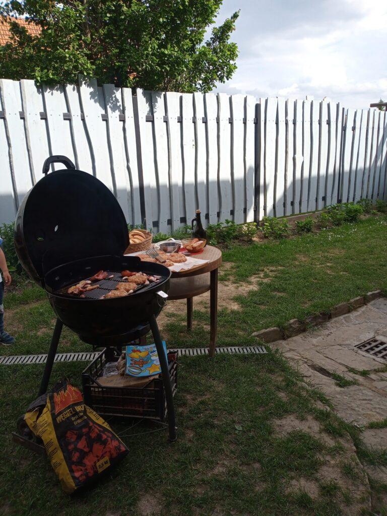 Zdjęcie przedstawia urokliwy zakątek podwórka Apartmán Lastovička z ustawionym grillem ogrodowym — miejsce idealne na letnie spotkania i chwile relaksu na świeżym powietrzu.